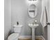 Cozy powder room featuring a pedestal sink, oval mirror, and neutral decor at 206 Cole Ct, Canton, GA 30114