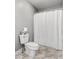 Bright bathroom featuring marble floors, a toilet, and a full shower with a white shower curtain at 206 Cole Ct, Canton, GA 30114