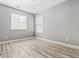 Bedroom with laminate wood floors, two windows, and light gray colored walls at 206 Cole Ct, Canton, GA 30114