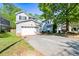 Two-story home with a two-car garage and a wide driveway lined with well-manicured lawn and mature trees at 206 Cole Ct, Canton, GA 30114