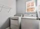 Efficient laundry room with washer, dryer, wire shelving, and a window for natural light at 206 Cole Ct, Canton, GA 30114