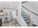 Hallway with wood-look floors, a staircase with black metal balusters, and access to the kitchen at 2424 Lakeshore Se Ln, Atlanta, GA 30316