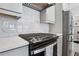 Close-up of modern kitchen stove with stylish backsplash and countertop at 2424 Lakeshore Se Ln, Atlanta, GA 30316