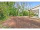 Large backyard with mature trees and a view of a covered porch at 5232 W Mountain St, Stone Mountain, GA 30083