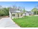 Well-manicured front yard and long driveway leading to a quaint, single-story home with a covered porch at 5232 W Mountain St, Stone Mountain, GA 30083