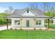 Charming single-story home featuring a covered front porch, green lawn, and a teal front door at 5232 W Mountain St, Stone Mountain, GA 30083