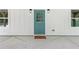 Close-up of the teal front door, framed by white siding and symmetrical windows at 5232 W Mountain St, Stone Mountain, GA 30083