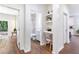 Hallway featuring wood flooring, a built-in desk area, and an open doorway leading to a bathroom at 5232 W Mountain St, Stone Mountain, GA 30083
