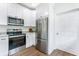Modern kitchen featuring stainless steel appliances, white cabinets, granite countertops, and wood-look flooring at 5232 W Mountain St, Stone Mountain, GA 30083
