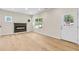 Bright living room showcasing a contemporary fireplace, hardwood floors, and multiple windows for natural light at 5232 W Mountain St, Stone Mountain, GA 30083