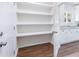 Walk-in pantry featuring white shelving, wood-look flooring, and ample storage space at 5232 W Mountain St, Stone Mountain, GA 30083