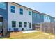 View of the backyard with a wood fence and a small concrete patio by the door of the two-story home at 7144 Gladstone Cir, Stonecrest, GA 30038
