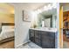Bathroom vanity with dual sinks, a large mirror, and a view of the bedroom at 7144 Gladstone Cir, Stonecrest, GA 30038