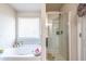 Bright bathroom featuring a soaking tub, separate shower, and tiled walls at 7144 Gladstone Cir, Stonecrest, GA 30038