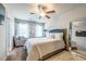 Bright bedroom with a cozy armchair, ceiling fan, and large mirror at 7144 Gladstone Cir, Stonecrest, GA 30038