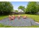 Backyard fire pit area featuring gravel, cozy seating, and ambient lighting for evening enjoyment at 2529 Ridgecrest Nw Dr, Kennesaw, GA 30152