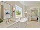 Bathroom with large window over soaking tub and elegant fixtures at 4059 Yellow Creek Trl, Cumming, GA 30028