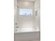 Modern bathroom with white marbled tile walls and a bright window above the tub at 4059 Yellow Creek Trl, Cumming, GA 30028