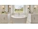 Bright bathroom featuring a soaking tub, dual vanities, and contemporary lighting at 4059 Yellow Creek Trl, Cumming, GA 30028