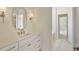 Stylish bathroom with a wide white vanity, contemporary lighting, and a view to an open doorway at 4059 Yellow Creek Trl, Cumming, GA 30028