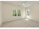 Well-lit bedroom featuring neutral carpet and multiple windows offering bright views at 4059 Yellow Creek Trl, Cumming, GA 30028