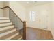 Inviting entryway with wood floors, staircase with wood and iron railing, and closet space at 4059 Yellow Creek Trl, Cumming, GA 30028
