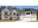 Stunning two-story modern farmhouse featuring a three car garage, manicured lawn and bright white siding at 4059 Yellow Creek Trl, Cumming, GA 30028