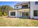 Exterior of home featuring spacious lawn and covered outdoor patio with sliding glass doors leading into the house at 4059 Yellow Creek Trl, Cumming, GA 30028