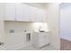 Bright laundry room with white cabinets and sink at 4059 Yellow Creek Trl, Cumming, GA 30028