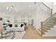 Open-concept living room with hardwood floors, white sofa, and access to the kitchen at 4059 Yellow Creek Trl, Cumming, GA 30028