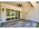 Spacious covered patio with stone floors, fan, and glass doors leading inside for seamless indoor-outdoor living at 4059 Yellow Creek Trl, Cumming, GA 30028