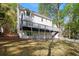 Backyard view of home with large deck, green lawn, and mature trees providing shade at 4477 Jett Nw Rd, Atlanta, GA 30327