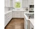 Modern kitchen featuring white cabinets, a marble backsplash and stainless steel appliances with beautiful hardwood floors at 4477 Jett Nw Rd, Atlanta, GA 30327