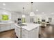 Modern kitchen featuring a large island, white cabinets, stainless steel appliances and hardwood flooring throughout the room at 4477 Jett Nw Rd, Atlanta, GA 30327