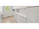 Bright laundry room features white cabinetry, marble backsplash, and a durable countertop for folding and sorting at 4477 Jett Nw Rd, Atlanta, GA 30327