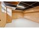 Unfinished basement space with white floors, wood paneled walls, and drop ceiling, offering potential for customization at 3826 Ensign Dr, Chamblee, GA 30341
