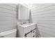 This bathroom offers a modern vanity, a sink with sleek fixtures, and stylish shiplap walls at 3826 Ensign Dr, Chamblee, GA 30341