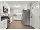 White kitchen features white cabinetry, stainless steel appliances, and tiled floors at 3826 Ensign Dr, Chamblee, GA 30341
