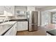 A bright kitchen featuring white cabinets, a stainless steel refrigerator, and a view of the backyard at 3826 Ensign Dr, Chamblee, GA 30341