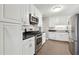 A well-lit kitchen with white cabinets, stainless steel appliances, and a black countertop at 3826 Ensign Dr, Chamblee, GA 30341