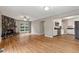 Open-concept living room with a cozy stone fireplace and hardwood floors, flowing into the kitchen at 3826 Ensign Dr, Chamblee, GA 30341