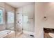 Bathroom featuring a glass-enclosed shower, a separate bathtub, and a window at 384 16Th Nw St # 1, Atlanta, GA 30363