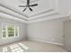 Bedroom with tray ceiling, window, and neutral paint at 6454 Meridian Way, Atlanta, GA 30328