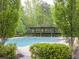 Community swimming pool featuring a pergola with columns and lush surrounding greenery at 6454 Meridian Way, Atlanta, GA 30328