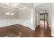 Dining room with hardwood floors, decorative wainscoting, modern chandelier, and an open hallway to the house at 6454 Meridian Way, Atlanta, GA 30328