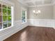 Formal dining room with hardwood floors, large windows, wainscoting, and a modern light fixture at 6454 Meridian Way, Atlanta, GA 30328