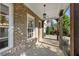 Inviting covered front porch with brick flooring and decorative columns, offering a cozy outdoor seating area at 6454 Meridian Way, Atlanta, GA 30328