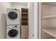 Convenient laundry room featuring a stacked washer and dryer, plus extra storage shelving at 6454 Meridian Way, Atlanta, GA 30328