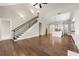 Bright open-concept living area featuring hardwood floors, staircase, and seamless flow to the kitchen area at 6454 Meridian Way, Atlanta, GA 30328