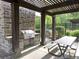 Outdoor kitchen with stone columns, a built-in grill, and a picnic table at 6454 Meridian Way, Atlanta, GA 30328
